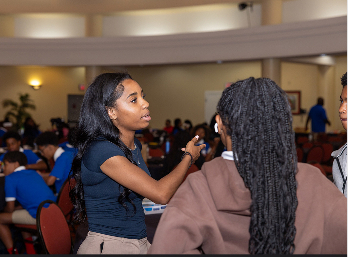 A mentor talking with a student during the AI in the D event